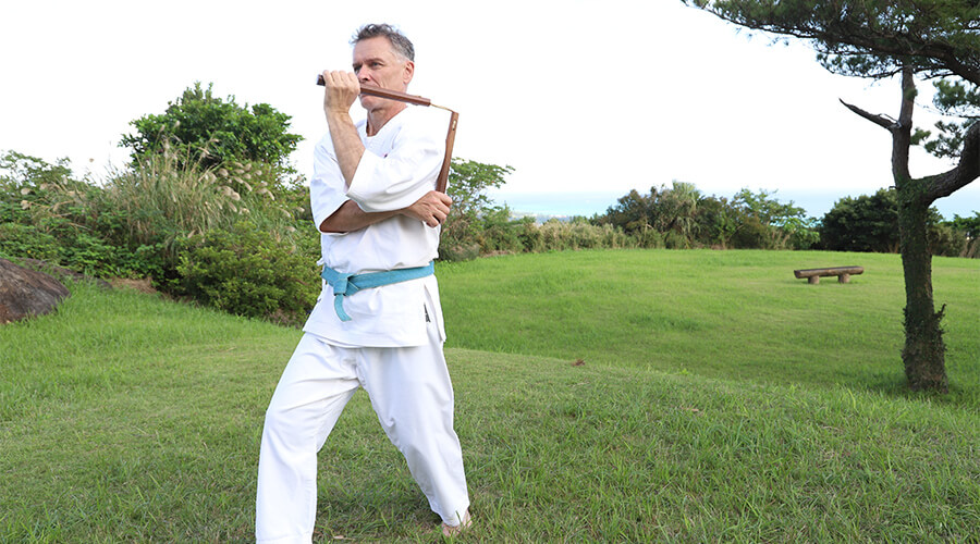 棒やヌンチャクなどを使って型を修練する沖縄古来の武器術